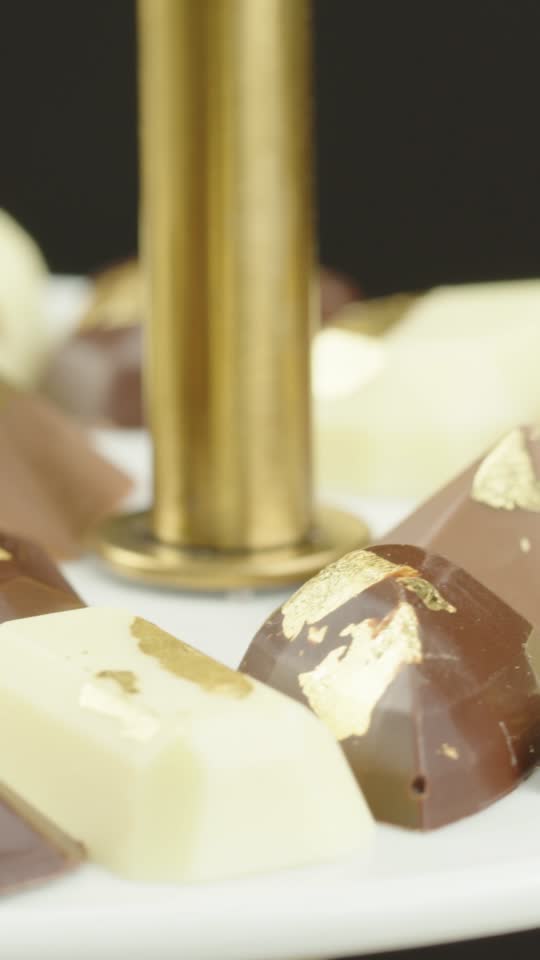 Closeup gold luster dust pours to pile of chocolate truffles on Stock